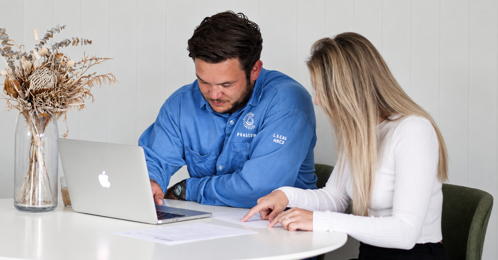 Brad and Dawn working together at a laptop and reviewing paperwork for Phased In